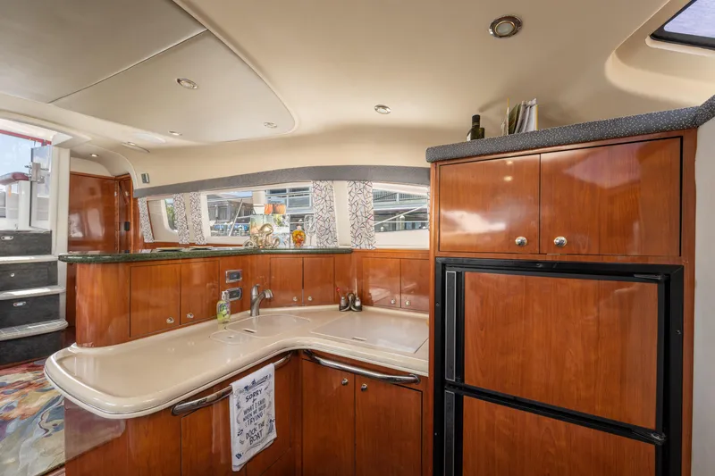 Slide: The Image of Luxurious 2003 Sea Ray 480 Motor Yacht interior with elegant wood cabinetry and modern kitchen amenities. - 51