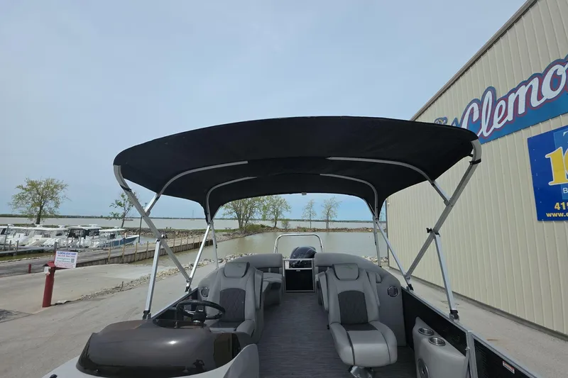Slide: The Image of 2021 Bennington LX 24 Quad Bench pontoon boat with canopy, docked near a marina. - 11