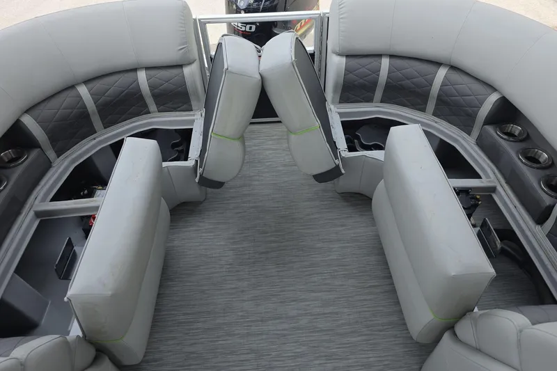Slide: The Image of 2021 Bennington LX 24 Quad Bench interior with gray seating and cup holders. - 16