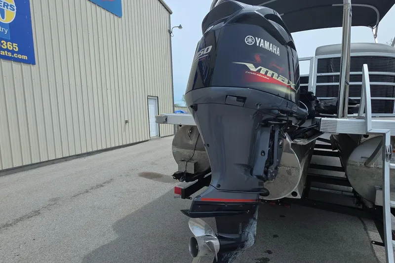 Slide: The Image of 2021 Bennington LX 24 Quad Bench with Yamaha outboard motor, parked near a building. - 4