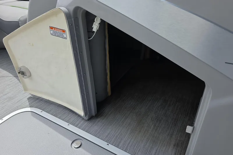 Slide: The Image of Open storage compartment on 2021 Bennington LX 24 Quad Bench boat interior. - 9