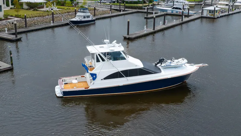 Slide: The Image of 1997 Ocean Yachts 60 Super Sport EB docked in a marina, featuring sleek design and fishing equipment. - 35