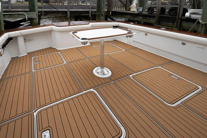 Slide: The Image of 1997 Ocean Yachts 60 Super Sport EB deck with teak flooring and table. - 44