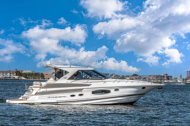 The Image of 2016 Regal 46 Sport Coupe yacht cruising on a sunny day with blue skies. - 1