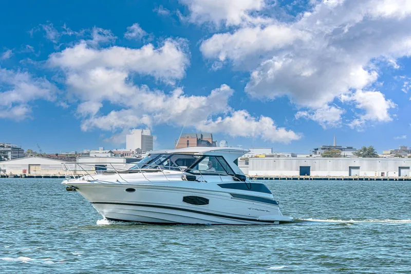 Slide: The Image of 2016 Regal 46 Sport Coupe cruising on a sunny day with cityscape background. - 76