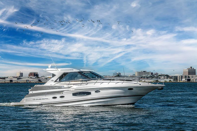 Slide: The Image of 2016 Regal 46 Sport Coupe cruising on water with city skyline in background. - 78