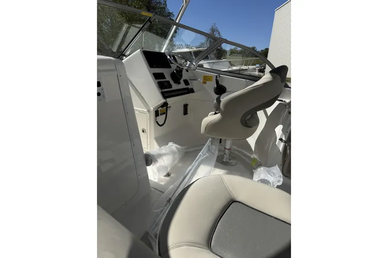 Slide: The Image of Interior view of 2026 Key West 239 DFS boat cockpit with steering wheel and seating. - 3