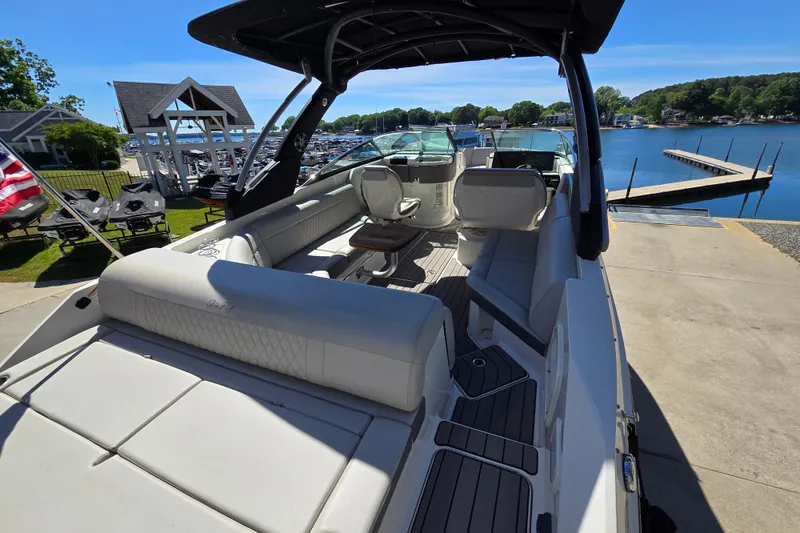 Slide: The Image of 2022 Sea Ray SLX 280 boat interior with seating, dockside view, and sunny weather. - 10
