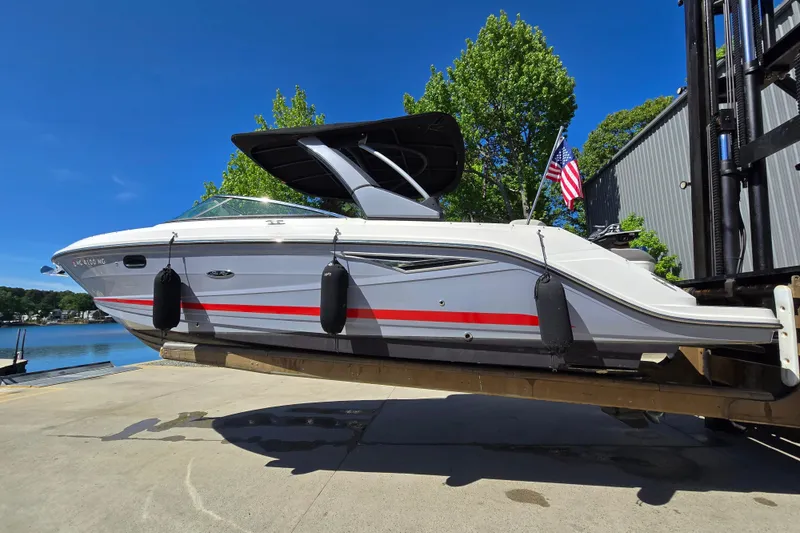 Slide: The Image of 2022 Sea Ray SLX 280 boat on dock, American flag, sunny day. - 2