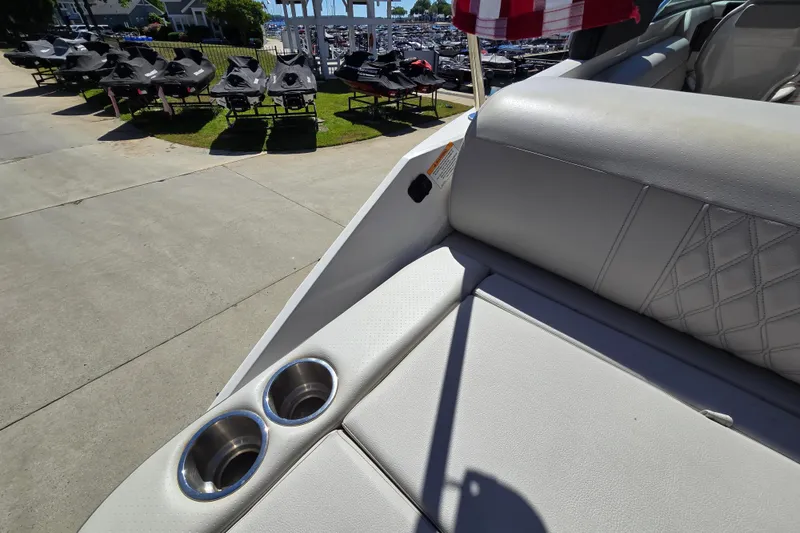 Slide: The Image of Luxury seating on 2022 Sea Ray SLX 280 boat with cup holders, docked near jet skis. - 21