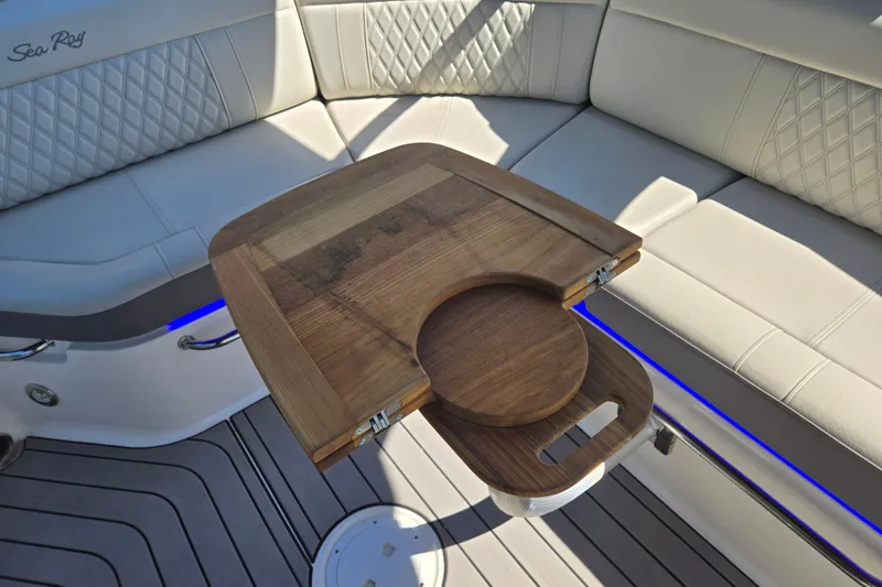 Slide: The Image of Luxurious interior of 2022 Sea Ray SLX 280 boat with wooden table and cushioned seating. - 25
