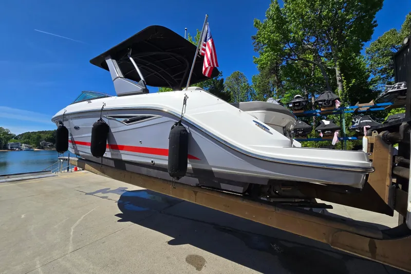 Slide: The Image of 2022 Sea Ray SLX 280 boat on trailer, dockside with American flag, sunny day. - 3