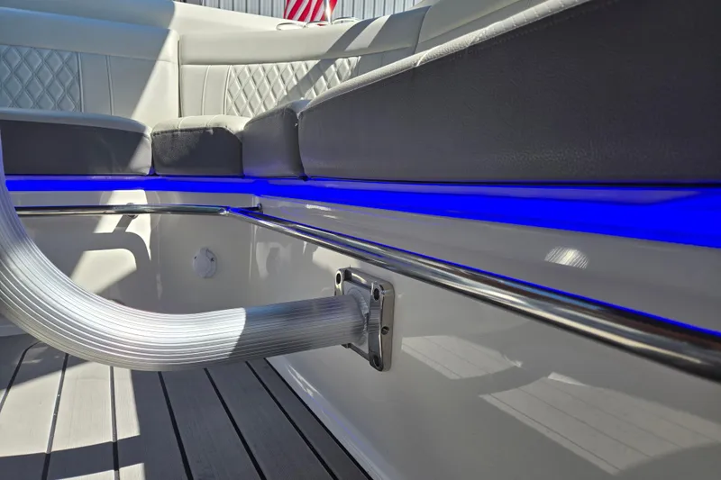 Slide: The Image of Interior of 2022 Sea Ray SLX 280 boat with blue LED lighting and cushioned seating. - 35