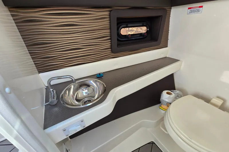 Slide: The Image of 2022 Sea Ray SLX 280 boat bathroom with sink, toilet, and textured wall design. - 39