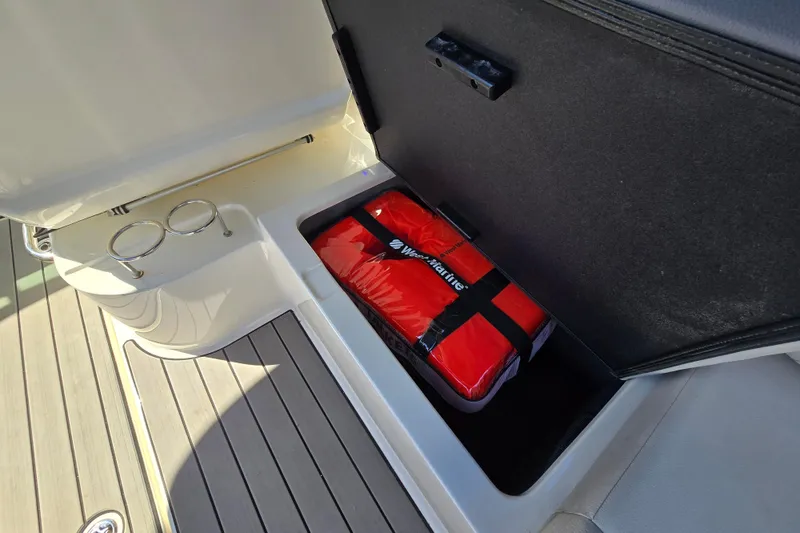 Slide: The Image of Storage compartment on 2022 Sea Ray SLX 280 boat with red safety equipment. - 42