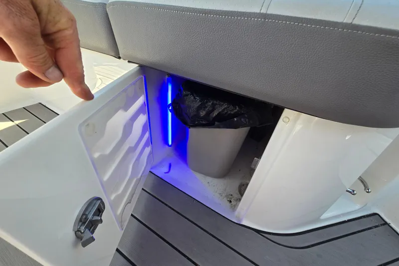 Slide: The Image of 2022 Sea Ray SLX 280 boat storage compartment with blue LED lighting. - 43