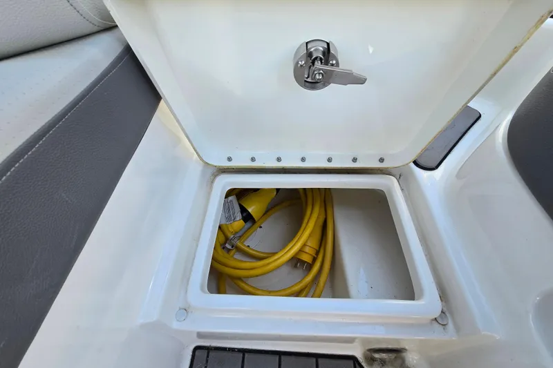 Slide: The Image of Storage compartment on a 2022 Sea Ray SLX 280 boat with yellow power cables. - 53