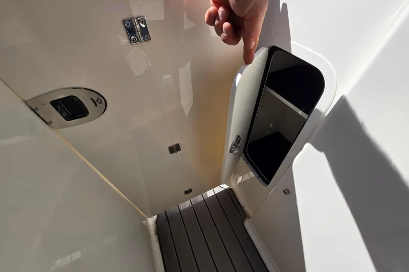 Slide: The Image of 2022 Sea Ray SLX 280 boat interior storage compartment with open door. - 61