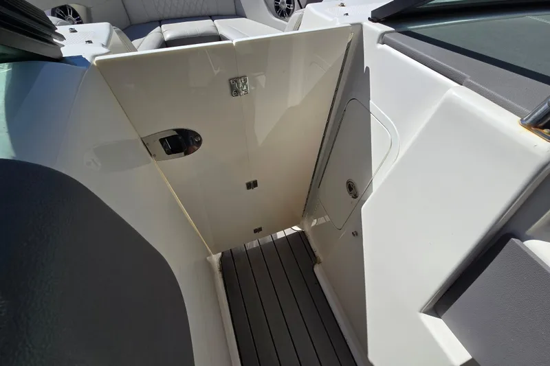 Slide: The Image of 2022 Sea Ray SLX 280 boat interior with open cabin door and seating area. - 62