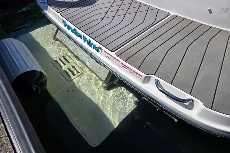 Slide: The Image of 2022 Sea Ray SLX 280 swim platform with water reflection and dock bumper. - 63
