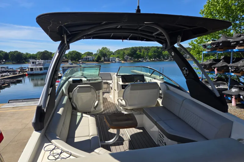 Slide: The Image of 2022 Sea Ray SLX 280 boat interior with seating, docked by a scenic lake. - 8