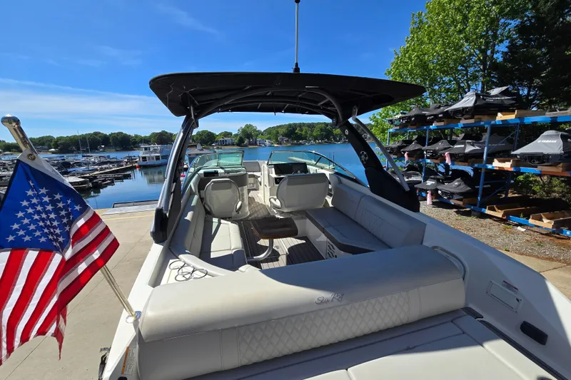 Slide: The Image of 2022 Sea Ray SLX 280 boat docked, featuring spacious seating and American flag. - 9