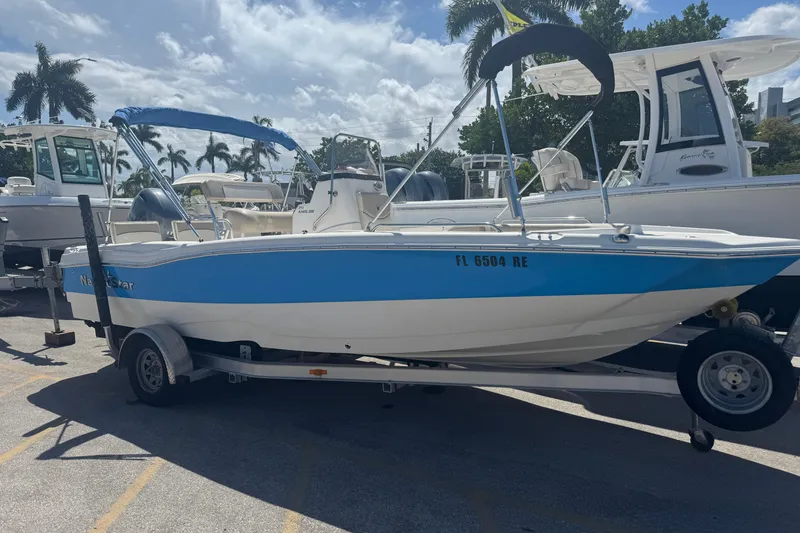 The Image of 2017 NauticStar 211 Angler boat on trailer, blue and white, parked outdoors. - 0