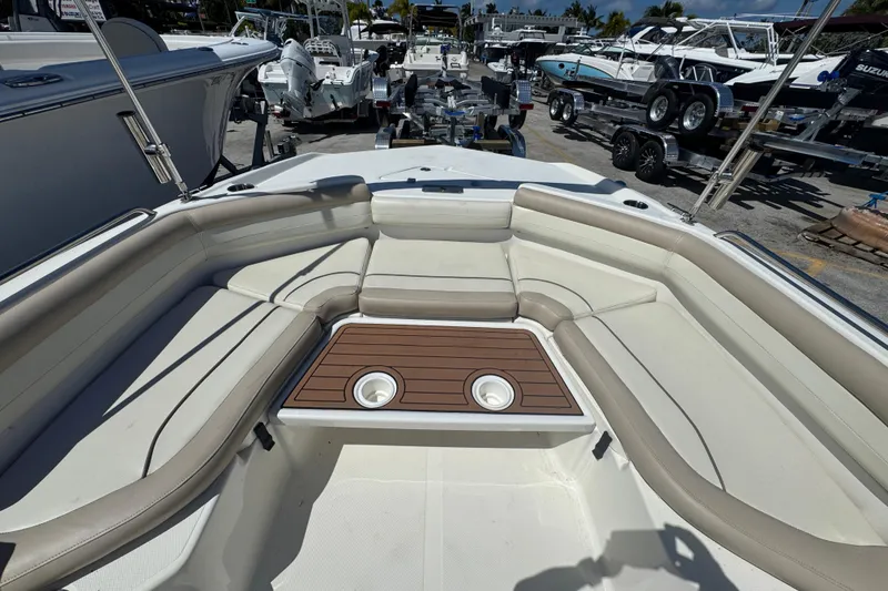 Slide: The Image of 2017 NauticStar 211 Angler boat interior with cushioned seating and wooden table. - 10