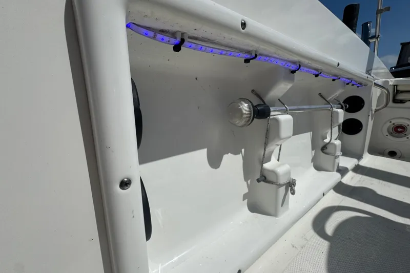 Slide: The Image of 2017 NauticStar 211 Angler boat interior with rod holders and blue LED lighting. - 14