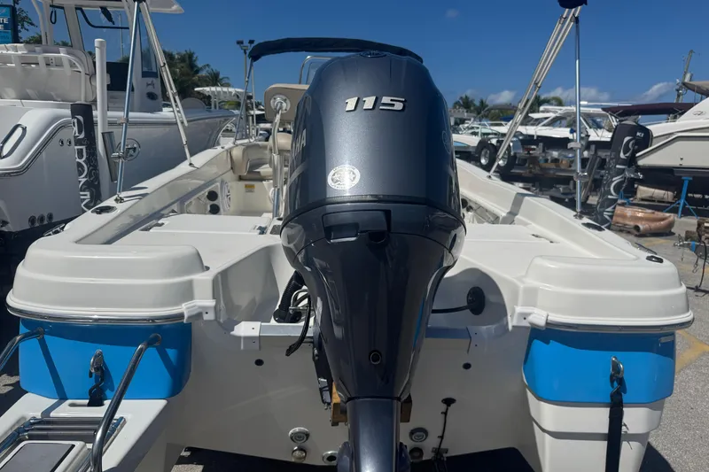Slide: The Image of 2017 NauticStar 211 Angler boat with Yamaha 115 outboard motor, docked in a marina. - 19