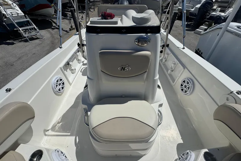 Slide: The Image of 2017 NauticStar 211 Angler boat interior with seating and console, featuring marine speakers. - 8