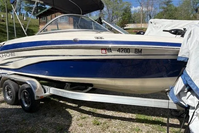 The Image of 2008 Tahoe Q6 SF boat on trailer, blue and white, parked outdoors. - 1