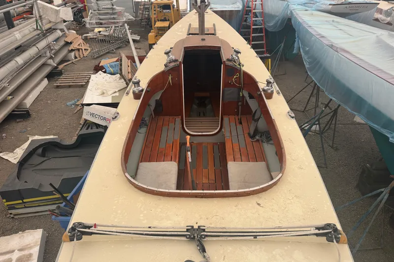 Slide: The Image of Restored 1944 Luders 24 sailboat in a shipyard, showcasing wooden deck and cockpit. - 14