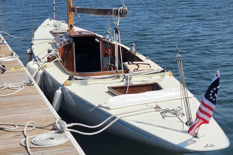 Slide: The Image of Vintage 1944 Luders 24 sailboat docked, featuring classic design and American flag. - 4