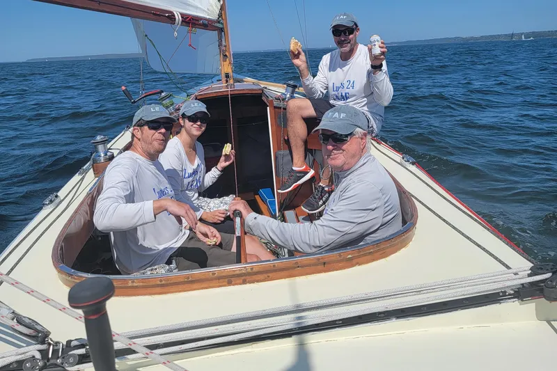 Slide: The Image of Sailors enjoying a day on a 1944 Luders 24 sailboat, surrounded by blue ocean waters. - 6