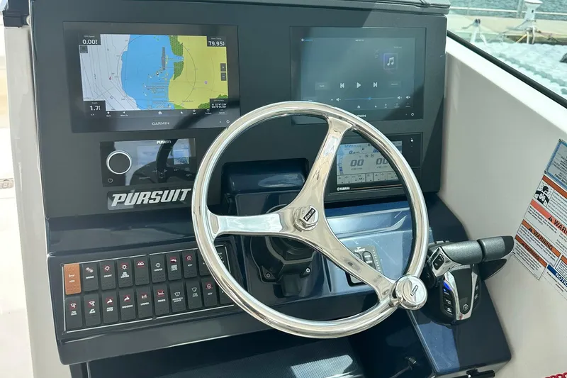 Slide: The Image of 2023 Pursuit DC 295 Dual Console dashboard with steering wheel and navigation displays. - 13