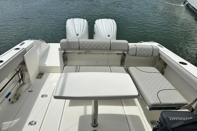 Slide: The Image of 2023 Pursuit DC 295 Dual Console boat interior with seating and table on water. - 19