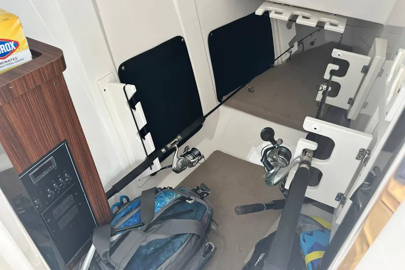 Slide: The Image of Interior of 2023 Pursuit DC 295 Dual Console with fishing gear and storage. - 20