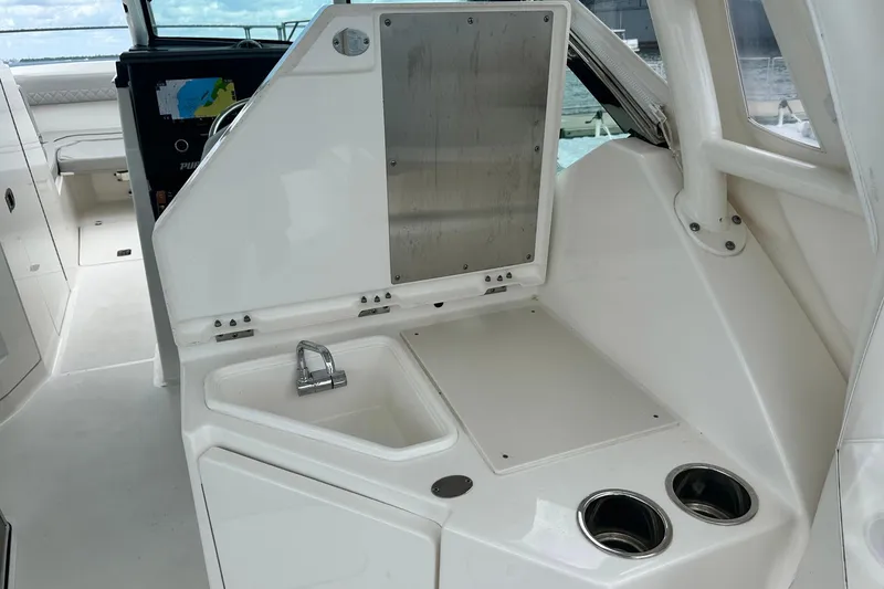 Slide: The Image of 2023 Pursuit DC 295 Dual Console boat interior with sink and storage area. - 22