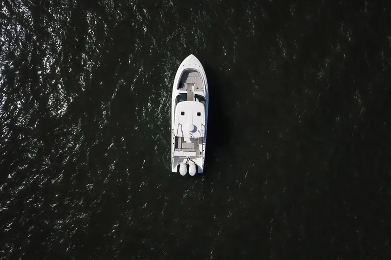 Slide: The Image of Aerial view of 2023 Pursuit DC 295 Dual Console boat on dark water. - 3