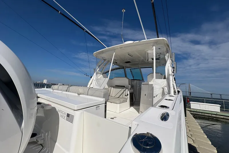 Slide: The Image of 2023 Pursuit DC 295 Dual Console boat docked under clear blue sky. - 7