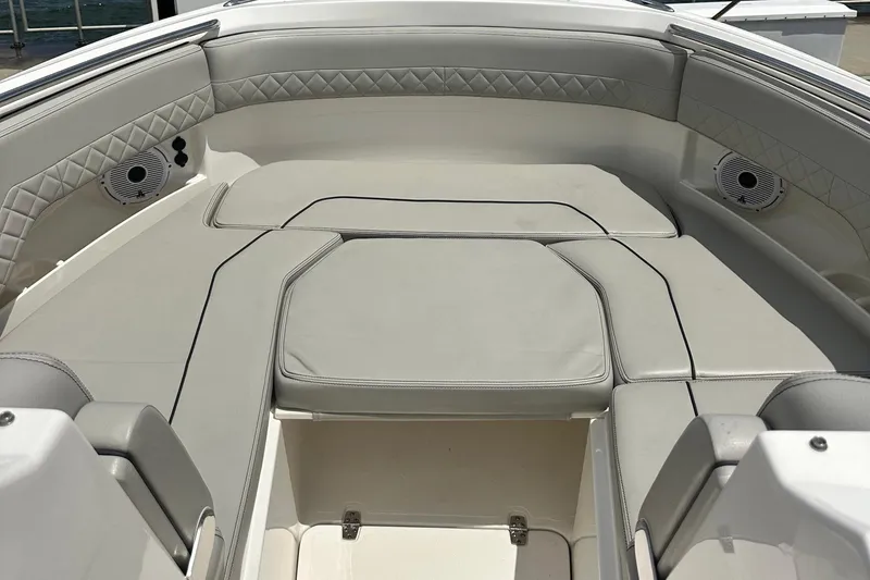 Slide: The Image of 2023 Pursuit DC 295 Dual Console boat interior with cushioned seating and speakers. - 9