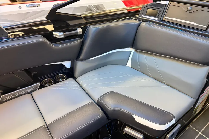 Slide: The Image of 2024 Supra SA boat interior with sleek black and gray seating, cup holders, and modern dashboard. - 3