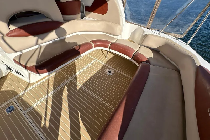 Slide: The Image of 1999 Sea Ray 380 Sundancer boat interior with cushioned seating and teak flooring. - 9