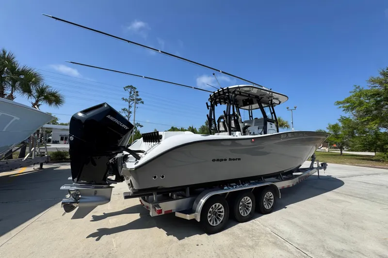 Slide: The Image of 2025 Cape Horn 32 XS boat on trailer, featuring Mercury outboard engine, under clear blue sky. - 11