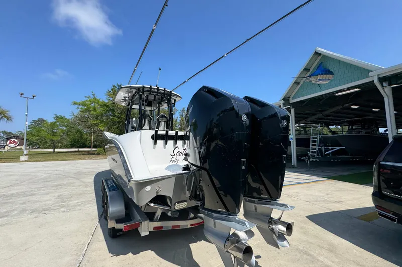 Slide: The Image of 2025 Cape Horn 32 XS boat with dual engines on a trailer, parked outdoors. - 15