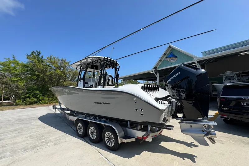Slide: The Image of 2025 Cape Horn 32 XS boat on trailer with Mercury engines, parked outdoors. - 16
