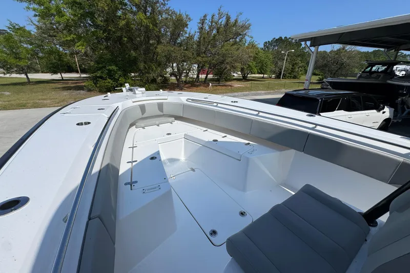 Slide: The Image of 2025 Cape Horn 32 XS boat interior with seating and storage, parked outdoors. - 19