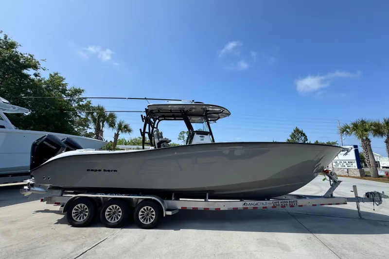 Slide: The Image of 2025 Cape Horn 32 XS boat on trailer, parked outdoors under clear blue sky. - 9