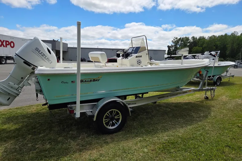 Slide: The Image of 2023 Bulls Bay 2000 boat on trailer with Suzuki outboard motor, parked on grass. - 5